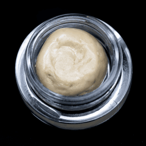 Close-up of Tropic Super Jet THCA Hash Rosin in a glass jar.