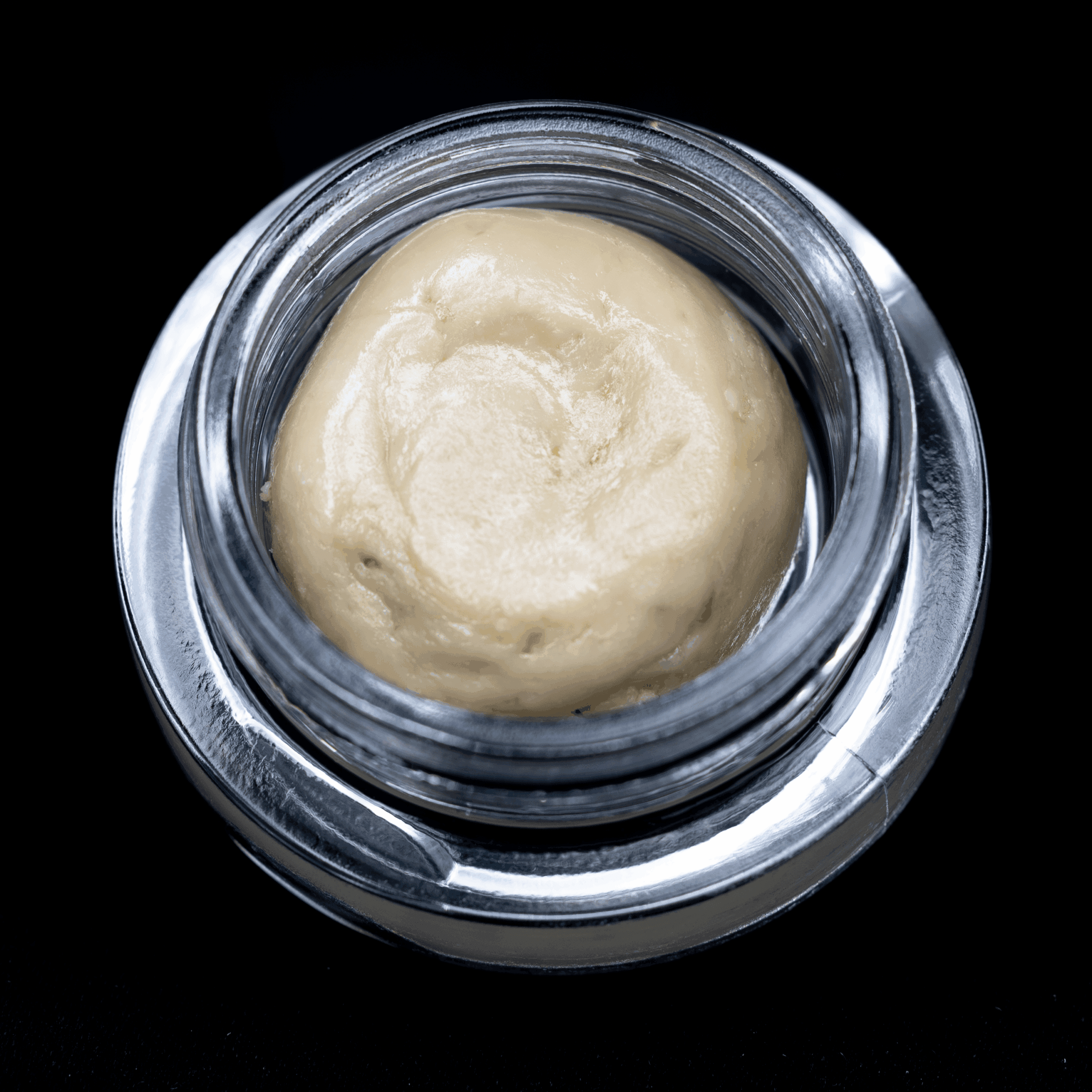 Close-up of Tropic Super Jet THCA Hash Rosin in a glass jar.