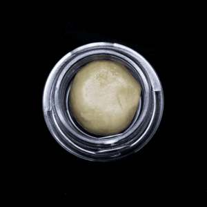 THCA Hash rosin concentrate in a glass jar, close-up view.